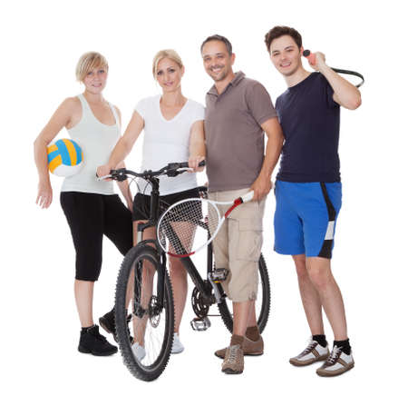 Portrait of a sporting family each holding their equipment of choice with a volley ball