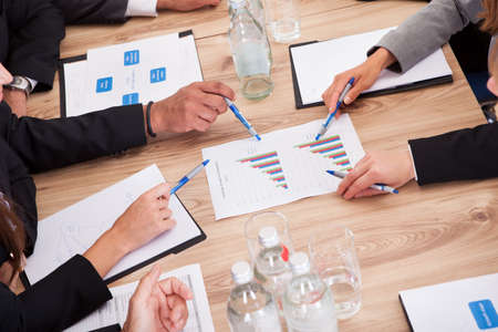 Close-up of Businesspeople Sitting At Conference Table Communicatingの写真素材