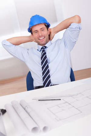 Portrait Of Architect Relaxing With Blueprint In The Officeの写真素材