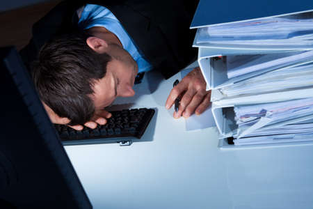 Tired Businessman Sleeping At Workplace In The Officeの写真素材