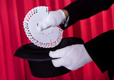 Magician Hand Holding Fanned Deck Of Cards From Hatの写真素材