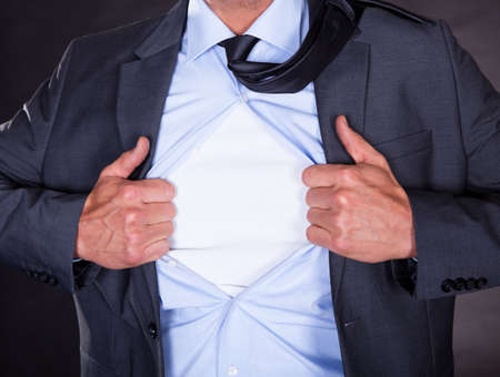 Superhero Tearing Off His Shirt On Black Backgroundの写真素材
