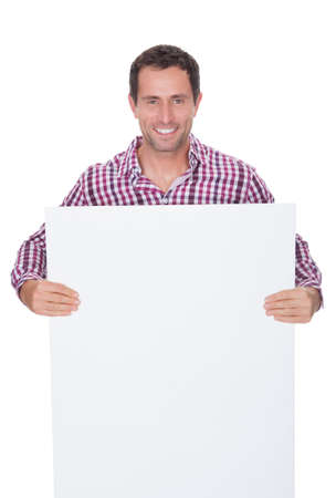 Portrait Of Young Man Holding Placard Isolated On White Backgroundの写真素材