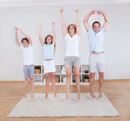 Family Doing Stretching Exercises On The Carpet At Homeの写真素材