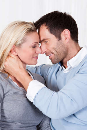 Playful lovely couple sitting together at home