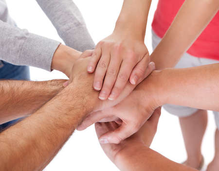 High angle conceptual teamwork and cooperation image of four casual middle-aged friends isolated on...