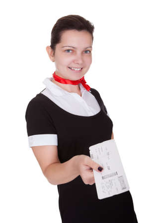 Stylish attractive flight attendant holding up an airline ticket in her hand isolated on whiteの写真素材