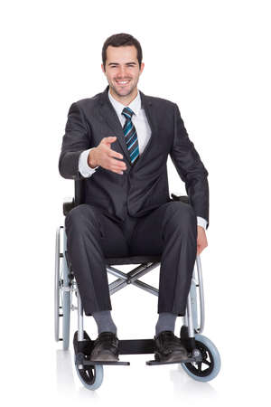 Young businessman in wheelchair. Isolated on whiteの写真素材