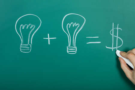 Turning ideas into cash concept on chalkboardの写真素材