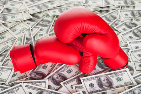 Boxing gloves on top of 100 dollars billsの写真素材
