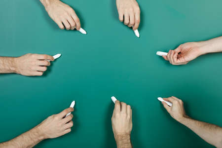Hand holding chalk writing on green blackboardの写真素材