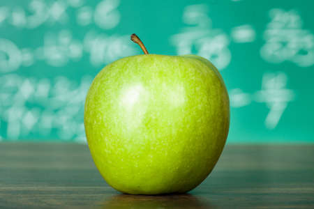 Photo of green apple on the school deskの写真素材