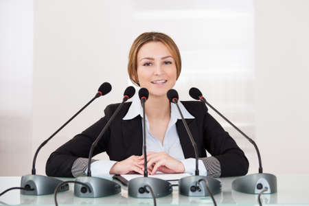 Young Cheerful Businesswoman Giving Speech In Conferenceの写真素材