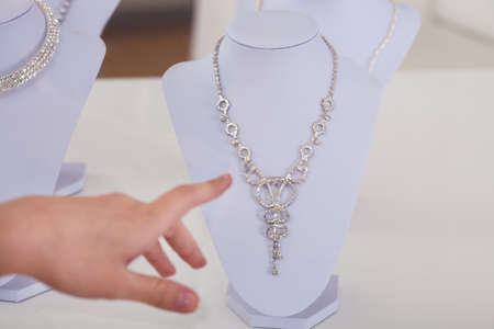 Woman's Hand Choosing Diamond Necklace In Shopの写真素材