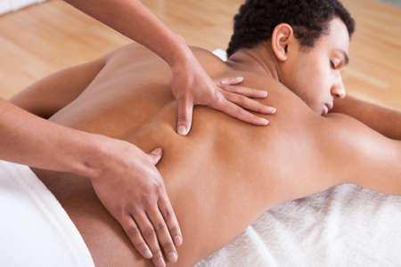 Portrait Of Man Receiving Massage Treatment From Female Handの写真素材