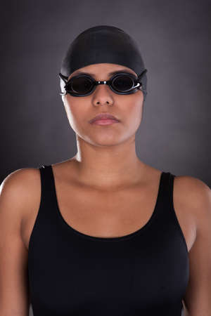 Portrait Of Young Female Swimmer Isolated Over Black Backgroundの写真素材