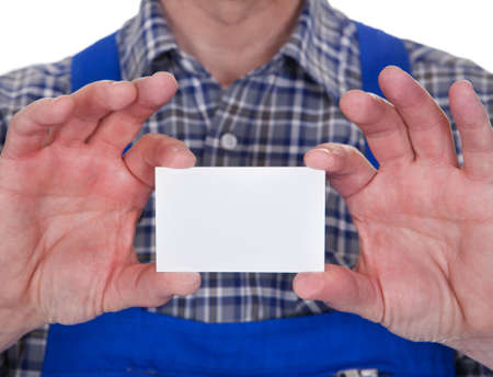 Mature Male Technician Holding Visiting Card Over White Backgroundの写真素材