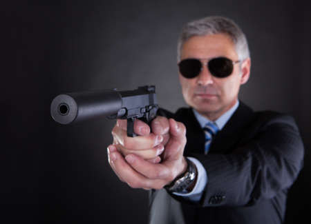 Close-up Of Male With Handgun Over Black Backgroundの写真素材
