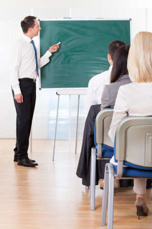 Business Man Writing On Board In Officeの写真素材