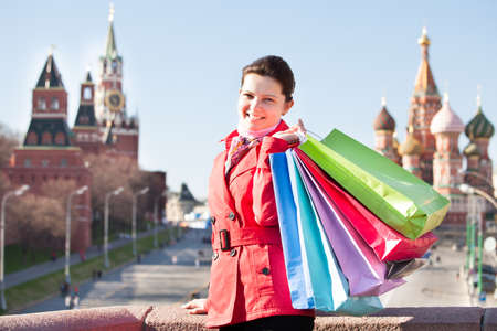 Happy young woman with shopping bags walking on streetの写真素材