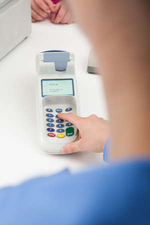 Close-up Of Finger Entering The Pin Code In Card Reader Machine