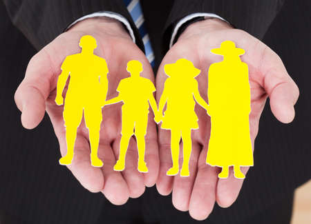 Close-up Of Male Hand Holding Family Cutout Shapeの写真素材