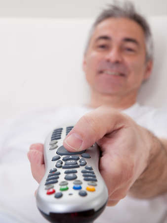 Portrait Of Happy Mature Man Holding Remote Controlの写真素材