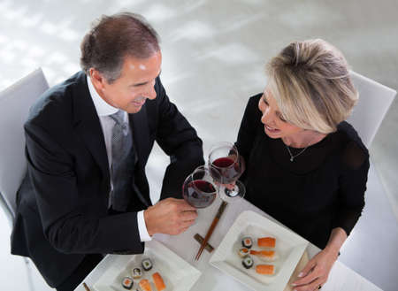 Happy Mature Couple Toasting Wine In A Elegant Restaurantの写真素材