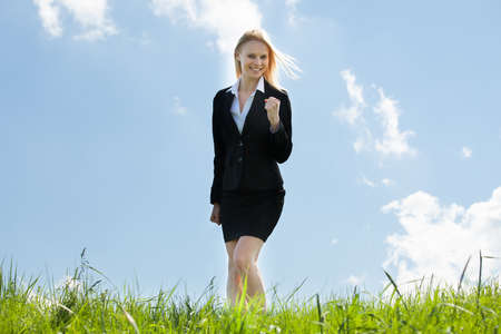 Successful Excited Business Woman Standing In Grassの写真素材