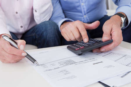 Close-up of mature couple doing finances at homeの写真素材