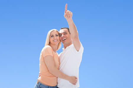 Woman Looking At Man Pointing On Sky Outdoorsの写真素材