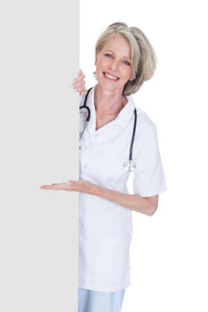 Female Doctor Holding Placard Over White Backgroundの写真素材