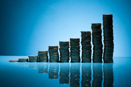 Stack Of One Euro Coins Over Blue Backgroundの写真素材