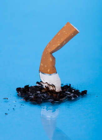 End Of Burning Cigarette Over Blue Backgroundの写真素材