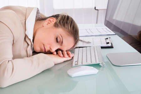 Tired business woman working in the officeの写真素材