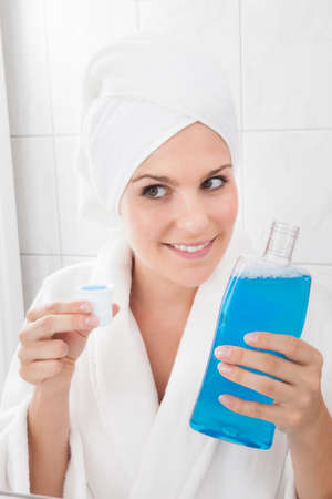 Young Happy Woman Holding Bottle Of Mouthwashの写真素材