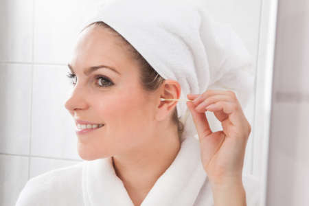 Young Beautiful Woman Cleaning Ear With Cotton Swabの写真素材