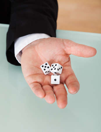 Close up of businessman in suit holding diceの写真素材