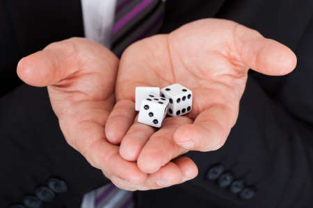 Close up of businessman in suit holding dice