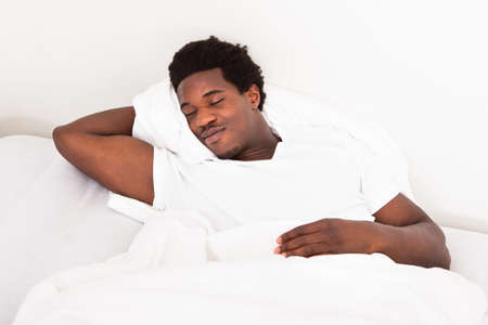 Handsome Young African Male Sleeping In Bed At Home