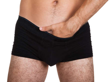 Close-up of man putting his hand inside underwear