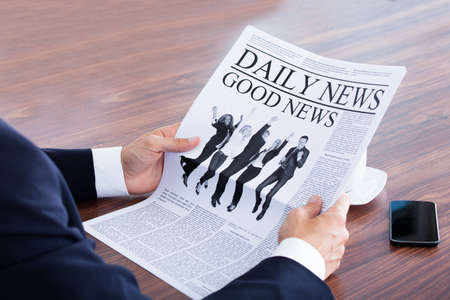 Close-up Of Businessman Reading News On Newspaperの写真素材