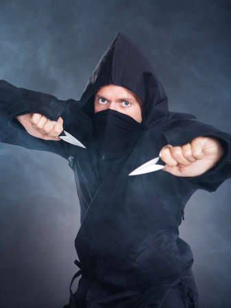 Portrait Of Male Ninja In Black Costume Holding Sword