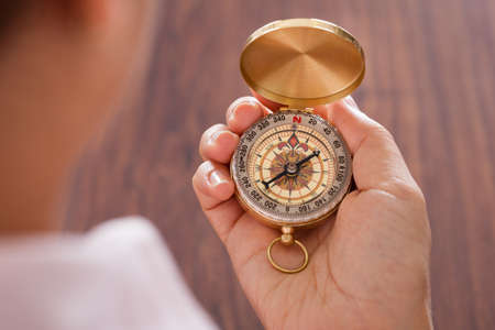 Close-up Of Female Hand Holding Compass In Handの写真素材