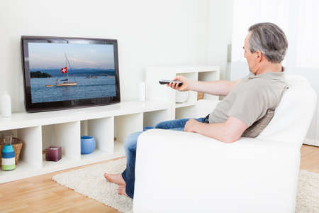 Portrait of a mature man watching tv at home