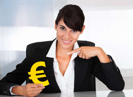 Close-up Of Hand Holding Yellow Euro Sign In Handの写真素材