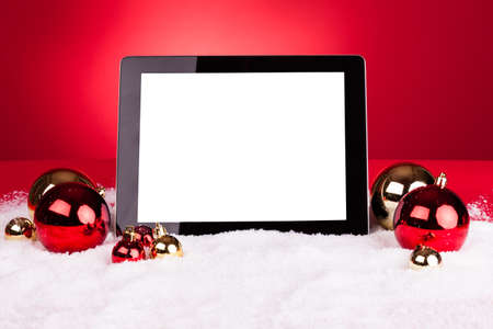 Blank Digital Tablet With Christmas Baubles On Red Backgroundの写真素材
