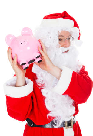 Santa holding piggy bank on white backgroundの写真素材