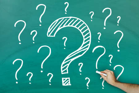 Hand writing lots of questions on green blackboardの写真素材