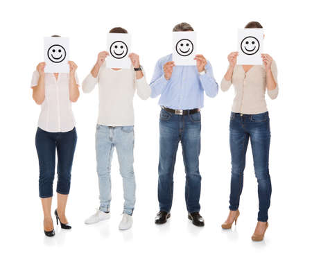 Group Of A People Holding Smiley In Front Of Their Faceの写真素材